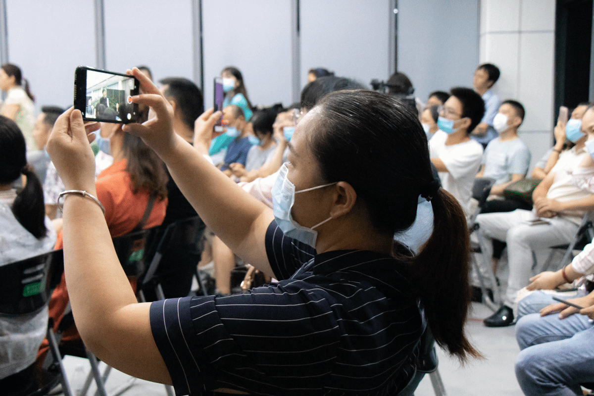 一名新生家长用手机录制高翅书记讲话【学通社记者 邵子衿 摄】