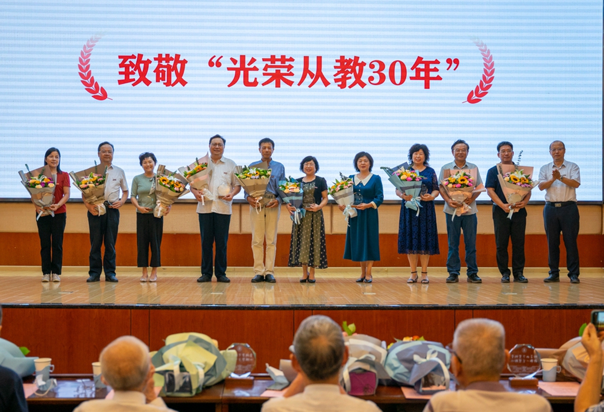 校长李召虎为在职教师颁发“光荣从教30年”纪念牌(学通社记者 杨宇轩 摄)